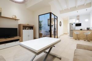 a living room with a white table and a kitchen at Luxury Apartment Peñuelas Free Parking in Seville