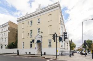 a large white building on the corner of a street at Earls Court Hotel in London