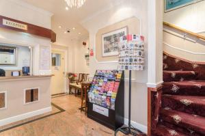 a store with a staircase in a room with a pharmacy at Earls Court Hotel in London