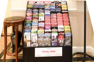 a table topped with lots of different types of books at Earls Court Hotel in London