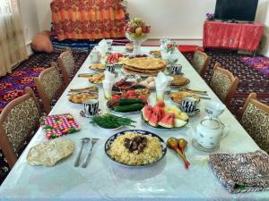 ein langer Tisch mit Essen darüber in der Unterkunft Western house in Qorowul