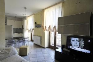 un soggiorno con divano e TV e una cucina di Palazzo Bertazzi a Verbania