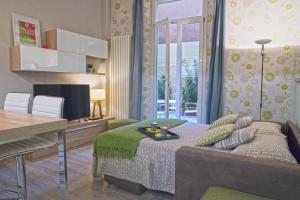 a bedroom with a bed and a table and a desk at Borgonuovo Apartments in Bologna