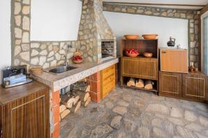 ヴェリングラードにあるApartments Ivadoniの石壁のキッチン(シンク付)