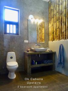 a bathroom with a toilet and a sink and a mirror at Ok Cabana Negombo in Negombo +37 photos