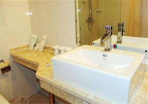 a bathroom with a white sink and a mirror at GreenTree Inn Tianjin Dasi Meijiang exhibition center Business Hotel in Tianjin