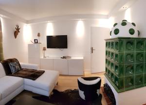 a living room with a white couch and a tv at Jagd trifft Moderne & Boutique Jardin Ferienhaus in Annaberg im Lammertal