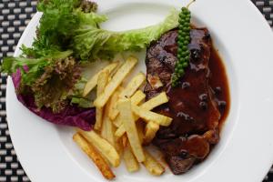 a plate of food with steak and french fries at Aroma Angkor Boutique Hotel in Siem Reap