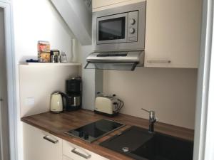 a small kitchen with a sink and a microwave at Chiemgautraum in Siegsdorf