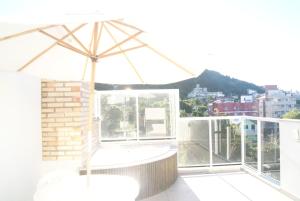 una sombrilla en la parte superior de un balcón en Bombinhas Quinta do Mar Complexo B, en Bombinhas