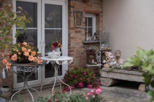 a patio with a table and flowers and a window at Sonnenhof Plauen in Plauen