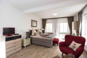 a bedroom with a bed and a red chair at Sonnenhof Plauen in Plauen