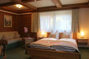 ein Schlafzimmer mit einem großen Bett und einem Fenster in der Unterkunft Alpenperle in Berwang