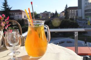 Ein Glas Orangensaft auf einem Tisch mit zwei Gläsern in der Unterkunft Hotel Luna in Žiar nad Hronom