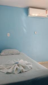 een bed in een kamer met een blauwe muur bij Pousada MG in Foz do Iguaçu