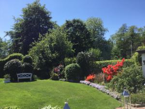 een tuin met bloemen en een bank in het gras bij Haus Utspann in Leck