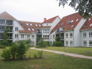 a row of white buildings with red roofs at Likedeeler Whg. 7 in Boltenhagen