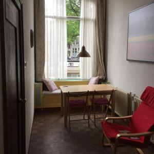 a room with a table and chairs and a window at Truelove Guesthouse in Amsterdam
