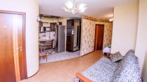 a living room with a couch and a kitchen at Центр! Папанинцев 111-157 in Barnaul