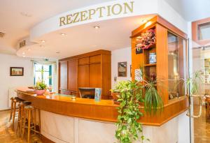 a kitchen with a reception counter with plants at Hotel Stadt Waren in Waren