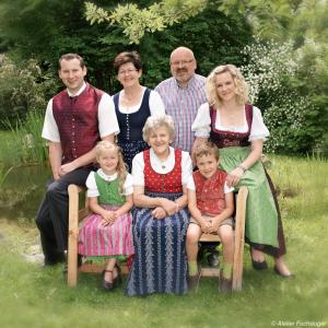 Eine Familie, die für ein Bild im Gras posiert in der Unterkunft Perbersdorfer Heuriger in Neuhofen an der Ybbs