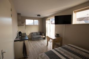 a bedroom with a bed and a kitchen and a table at Zon Zee Zoutelande in Zoutelande