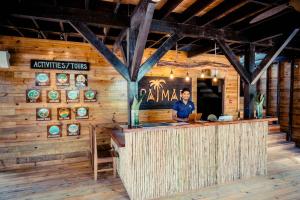 Palmar Beach Lodge في بوكاس تاون: رجل يقف عند بار في مطعم