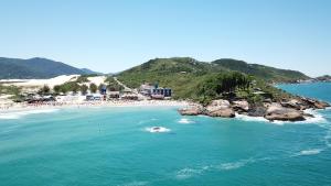 an aerial view of a beach with rocks in the water at Cris Hotel in Florianópolis
