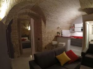 a living room with a couch and a brick wall at Al Castello in Cagliari