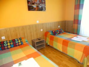 a room with two beds and a small table at Pension Plaza in Quinto