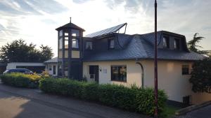 ein Haus mit einem Uhrturm auf einer Straße in der Unterkunft Gästehaus Sproß in Veldenz