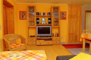 una sala de estar con TV en un centro de entretenimiento de madera en Ferienwohnung Kaufmann, en Baiersbronn