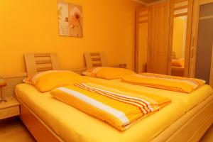 バイアースブロンにあるFerienwohnung Kaufmannのオレンジ色の壁と黄色を用いた客室のベッド2台