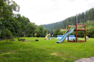 a park with a playground with slides in the grass at Apartman Sverana in Velké Karlovice