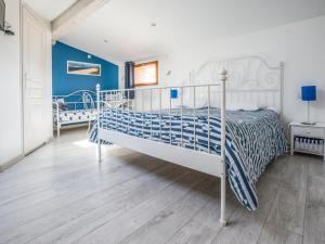 ein Schlafzimmer mit einem Bett in einem Zimmer mit blauen Wänden in der Unterkunft Le Médoc de Maxou in Lamarque