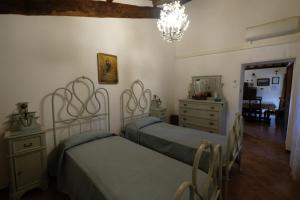 Civitella dʼAglianoにあるLa casetta dei Gelsiのベッドルーム1室(ベッド2台、ドレッサー、鏡付)
