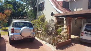 a white car parked in front of a house at The Fairway in Cape Town