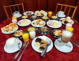 a table topped with plates of food and cups of coffee at Hotel Eo Park in San Clemente del Tuyú
