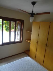 sala de estar con ventilador de techo y ventana en Bombinhas Quinta do Mar Complexo A, en Bombinhas