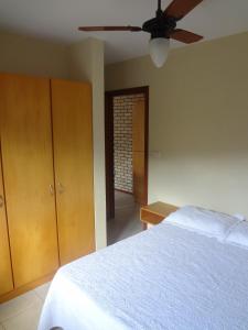 1 dormitorio con 1 cama y ventilador de techo en Bombinhas Quinta do Mar Complexo A, en Bombinhas