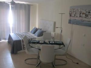 a bedroom with a bed and a table and chairs at Los Cristianos studio, modern, spacious, pool,WiFi in Arona