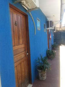 uma porta num quarto com uma parede azul em Pousada MG em Foz do Iguaçu