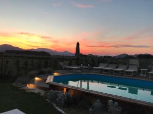 a swimming pool with a sunset in the background at Ca' Borgo delle Rane in Pernumia
