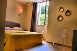 ラルジャンティエールにあるChambres d'hôtes Clos des Récolletsのベッドルーム1室(ベッド1台、椅子、窓付)