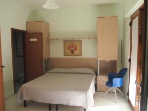 ein Schlafzimmer mit einem Bett und einem blauen Stuhl in der Unterkunft vista mare in Pineto
