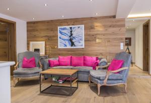 ein Wohnzimmer mit einem Sofa und 2 Stühlen in der Unterkunft Trendguide Suites by Alpine Host Helpers in Kirchberg in Tirol