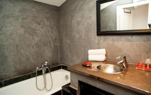 W łazience znajduje się umywalka, wanna i lustro. w obiekcie Hotel B Lodge w Saint-Tropez