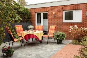 un patio avec une table et des chaises et un bâtiment dans l'établissement Lüttjeloog, à Leer