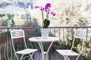 ナポリにあるIsa Guest Roomsのテーブルと椅子2脚、花瓶1本(バルコニー)