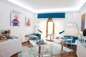 uma sala de estar branca com mesas e cadeiras em Isa Guest Rooms em Nápoles